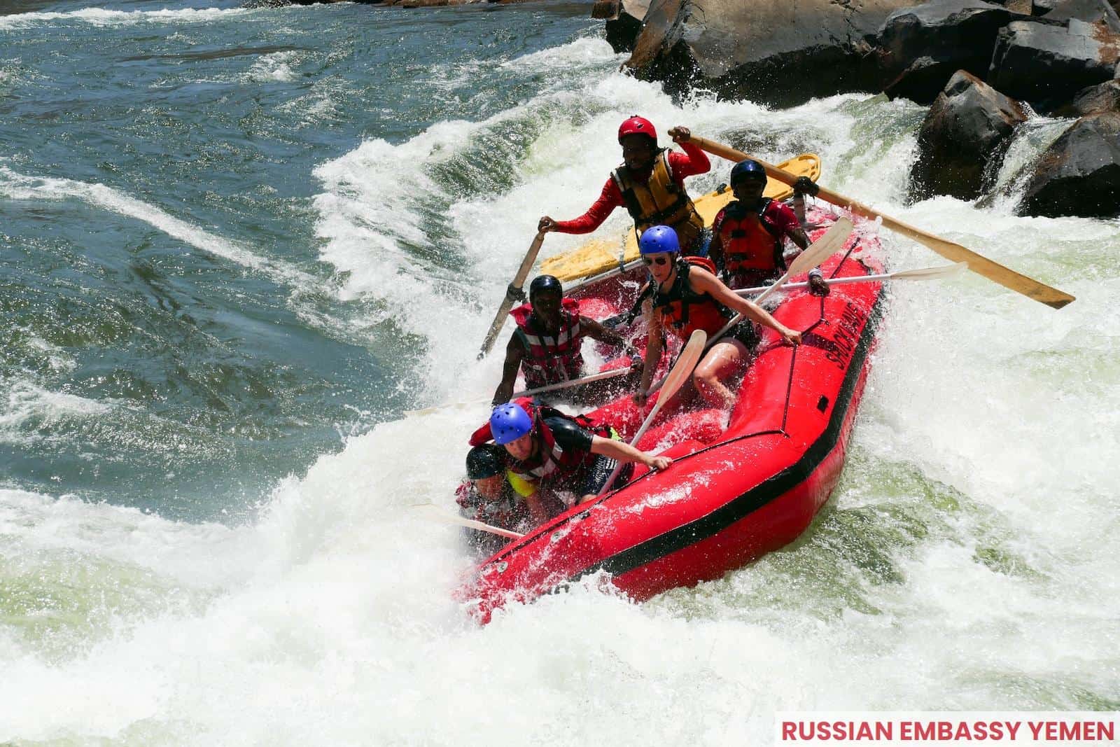 2 men riding red kayak on sea during daytime