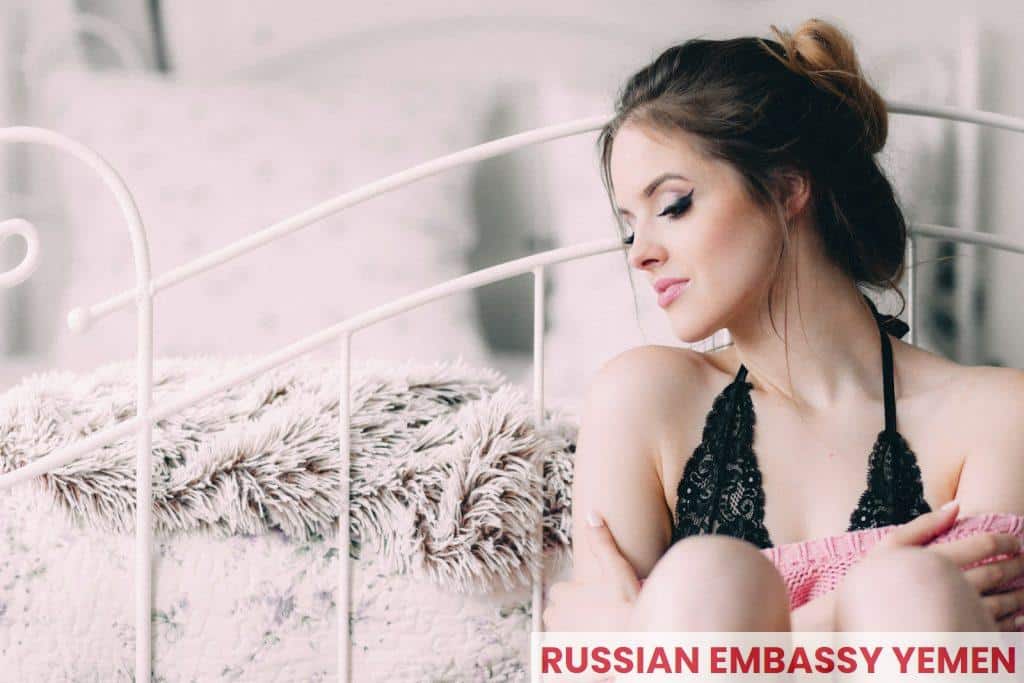 woman wearing black lingerie holding pink pillow